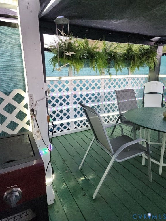 115 Katherine Street, Kings Borough, Suffolk, VA 23434 Covered outdoor deck featuring painted wood-finish decking, white latticework railing, and an overhead structural frame