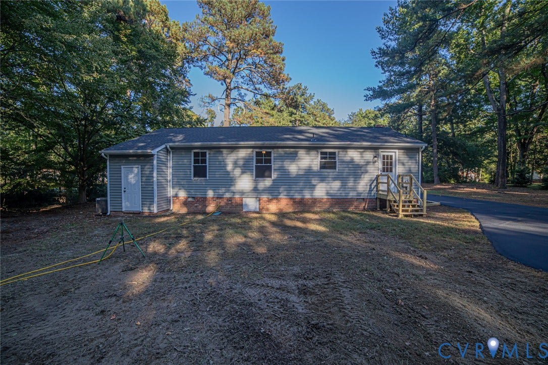 Exterior featuring horizontal siding, a brick foundation, asphalt shingle roofing, and a paved driveway