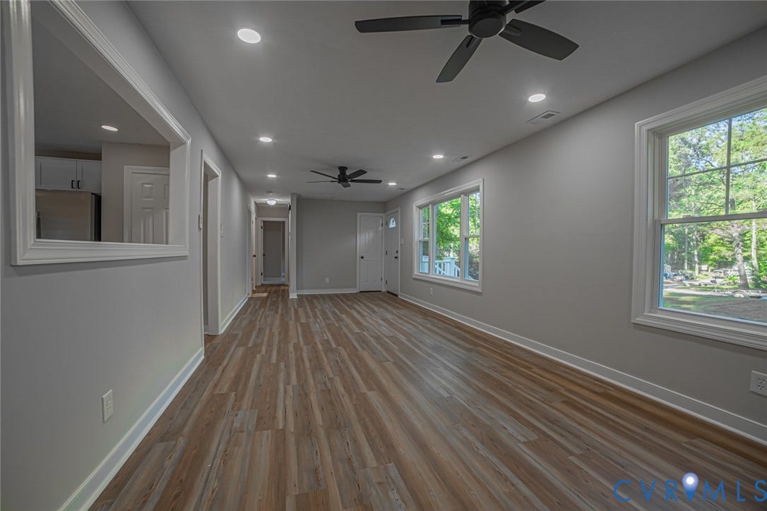 Interior space featuring wood-finish flooring, recessed lighting, dual matte black ceiling fans, and an interior pass-through window