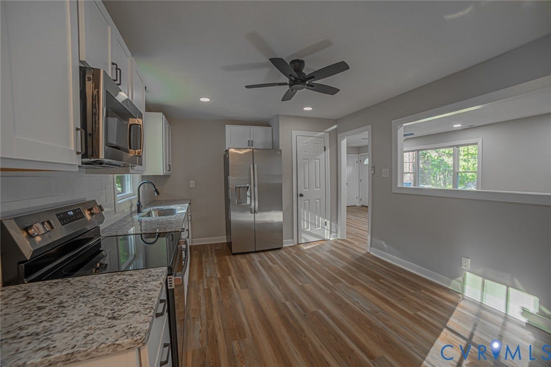 Kitchen featuring white cabinetry, stone-finish countertops, stainless steel appliances, wood-finish flooring, and a ceiling fan
