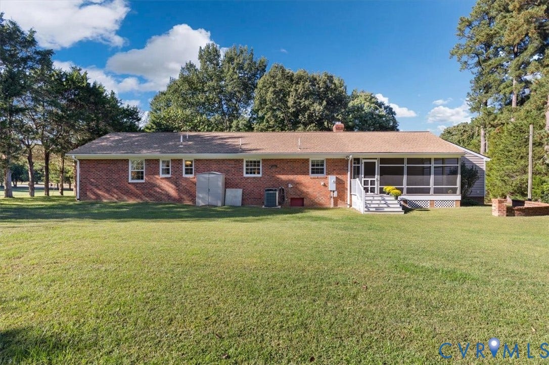 5111 Hurop Road, Sandston, VA 23150 Brick exterior residence featuring an expansive lawn, a screened-in porch with white railings, and mature surrounding trees