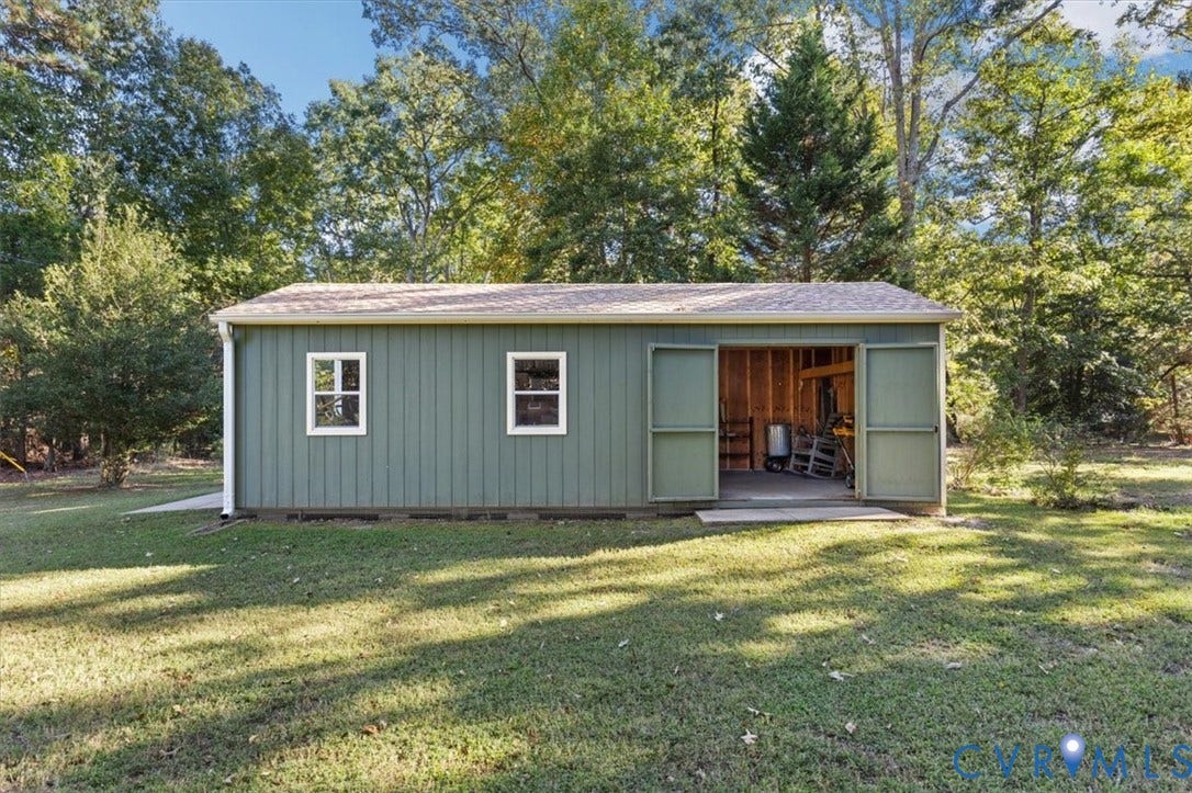 5111 Hurop Road, Sandston, VA 23150 Detached outbuilding featuring vertical siding, dual swing doors, a shingled roof, and two windows