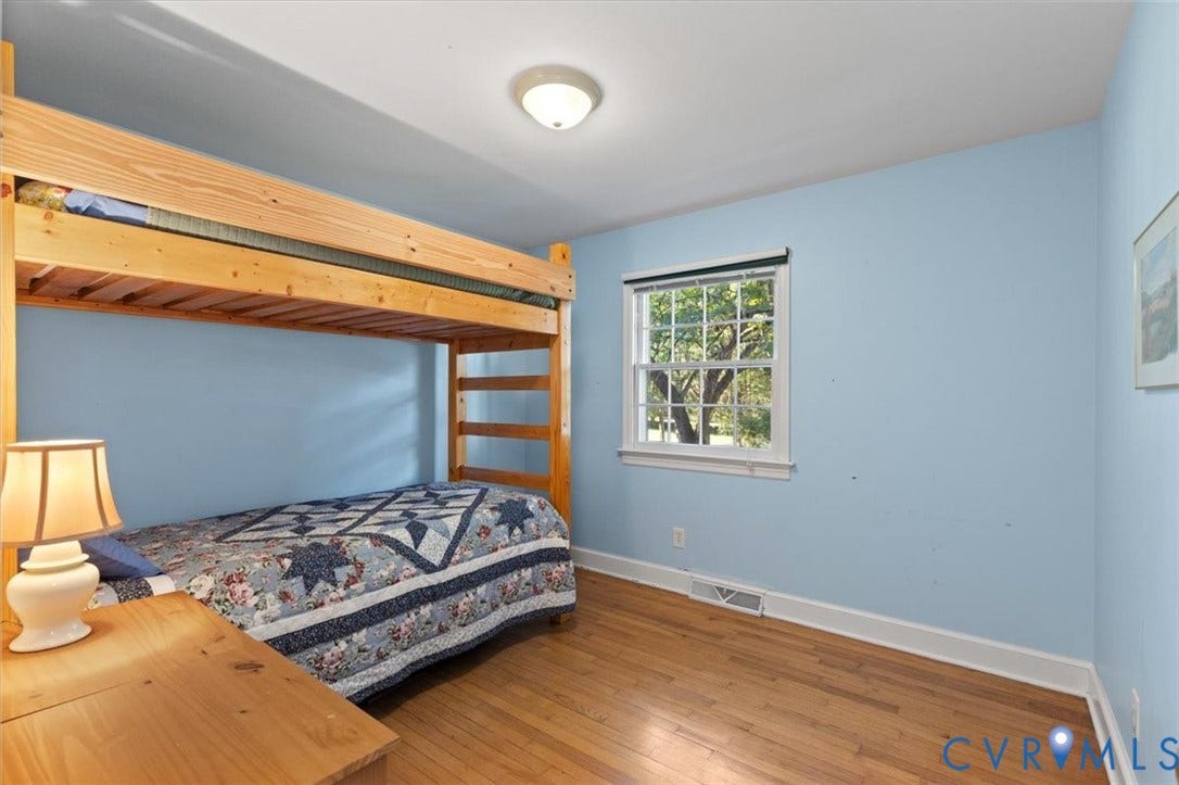 5111 Hurop Road, Sandston, VA 23150 Room featuring wood-finish flooring, a double-hung window with a screen, and a flush-mount ceiling light fixture
