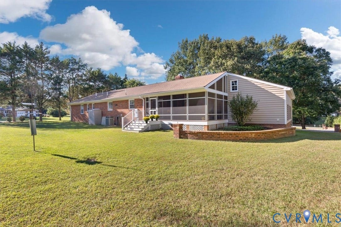 5111 Hurop Road, Sandston, VA 23150 Exterior features brick and vinyl siding, an enclosed screened porch, a multi-tiered brick retaining wall, and an expansive lawn