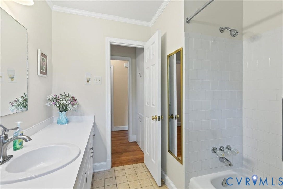 5111 Hurop Road, Sandston, VA 23150 Bathroom featuring a vanity with a white countertop and integrated sink, a built-in tub with white tile surround, and tile flooring