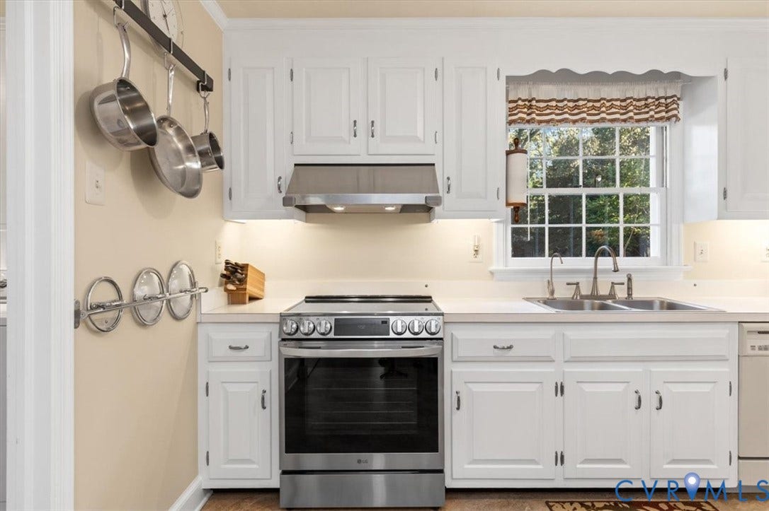 5111 Hurop Road, Sandston, VA 23150 Kitchen featuring white cabinetry, stainless steel range, matching stainless steel vent hood, solid surface countertops, and an integrated dual-basin sink