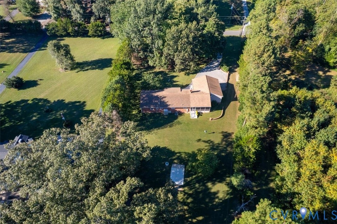 5111 Hurop Road, Sandston, VA 23150 Aerial perspective of a single-story residence featuring a shingled roof, paved driveway, rear screened-in porch, and extensive wooded grounds