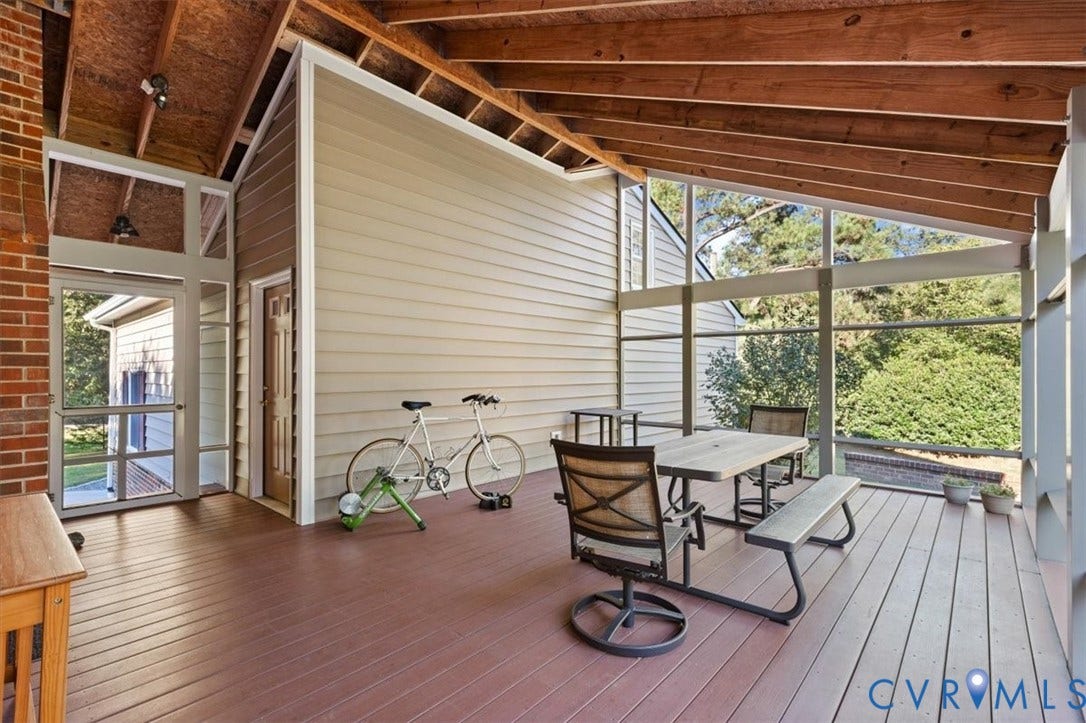 5111 Hurop Road, Sandston, VA 23150 Screened-in porch featuring a vaulted ceiling with exposed wood beams, composite decking, floor-to-ceiling windows, and red brick masonry detailing