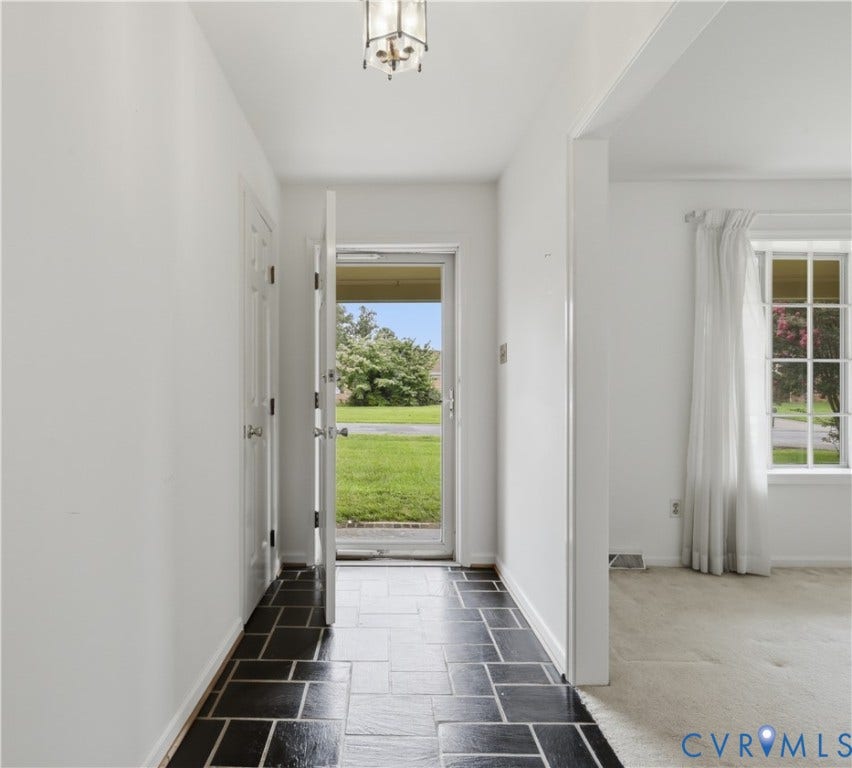 3641 Kiefer Road, Bermuda, Chester, VA 23831 Entryway featuring dark stone tile flooring, multi-pane window with grid pattern, recessed-panel door, and a multi-arm flush-mount light fixture