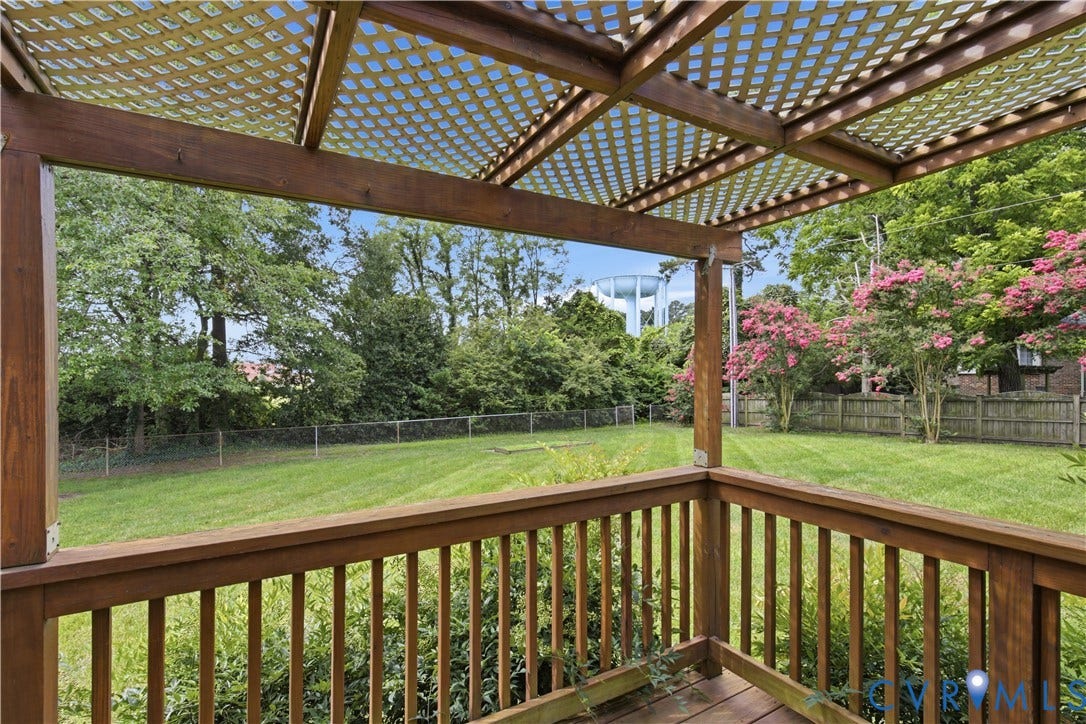 3641 Kiefer Road, Bermuda, Chester, VA 23831 Covered wood pergola featuring a lattice top and rail system, overlooking a fenced backyard with mature trees and established landscaping