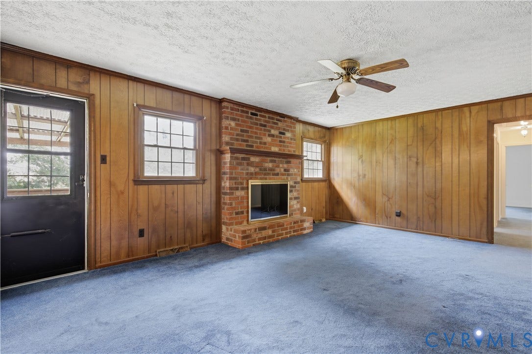 3641 Kiefer Road, Bermuda, Chester, VA 23831 Interior space featuring wood-paneled walls, a floor-to-ceiling brick fireplace, and a ceiling fan