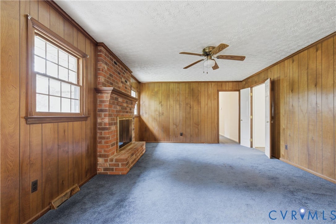 3641 Kiefer Road, Bermuda, Chester, VA 23831 Interior room featuring wood-paneled walls, a brick fireplace with a raised hearth, a multi-pane window, and a ceiling fan