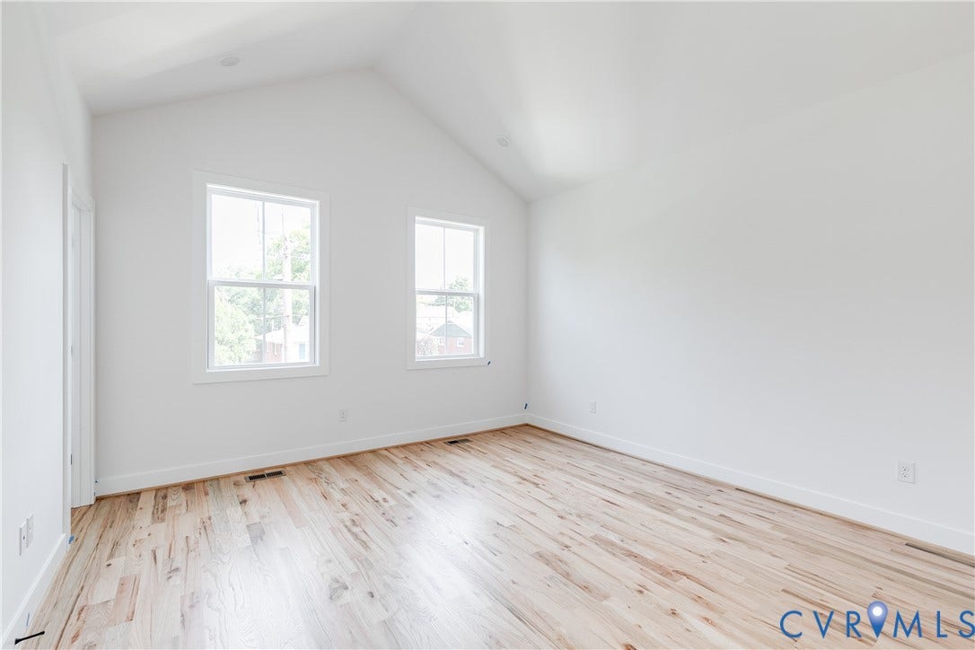 Vaulted ceilings, wood-finish flooring, and double-pane windows with muntin bars