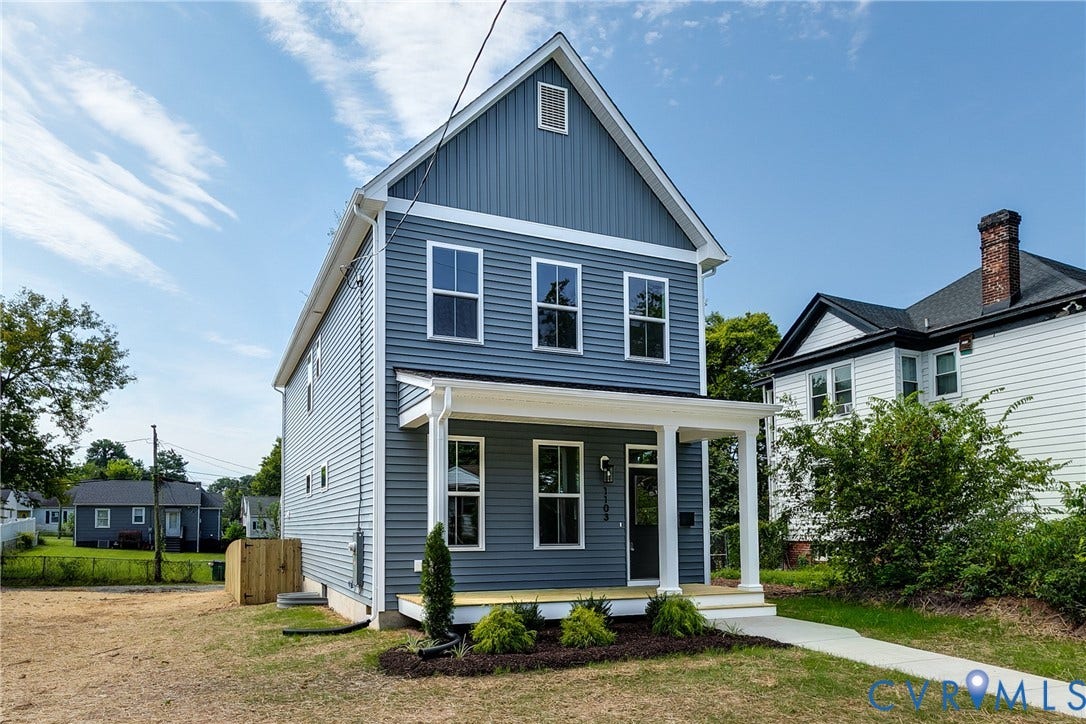 Two-story exterior featuring blue horizontal siding, white trim, a covered front porch with square columns, and a gable roofline