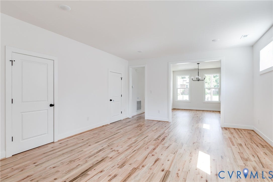 Interior space featuring light wood-finish flooring, recessed lighting, white panel doors, and a multi-light chandelier