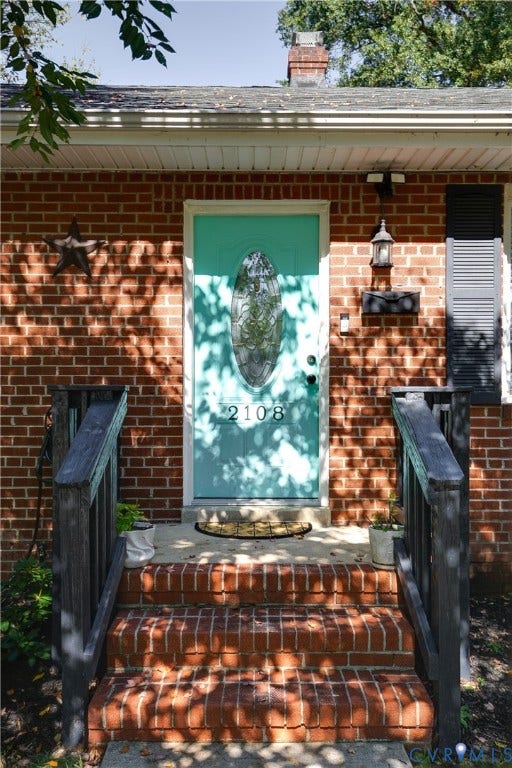 2108 Parkside Avenue, Henrico, VA 23228 Red brick exterior featuring a multi-pane glass insert front door, brick entryway steps, dark-tone handrails, and a chimney