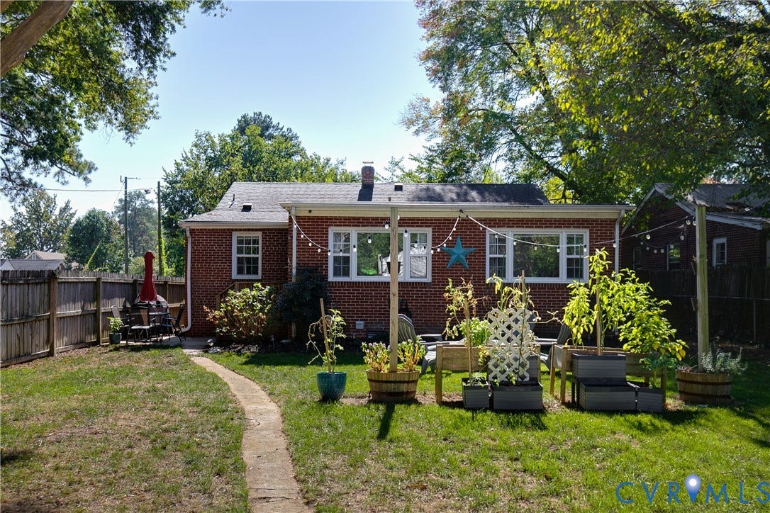 2108 Parkside Avenue, Henrico, VA 23228 Brick exterior featuring a multi-pane window configuration, a stone pathway, a wood privacy fence, and raised planter boxes