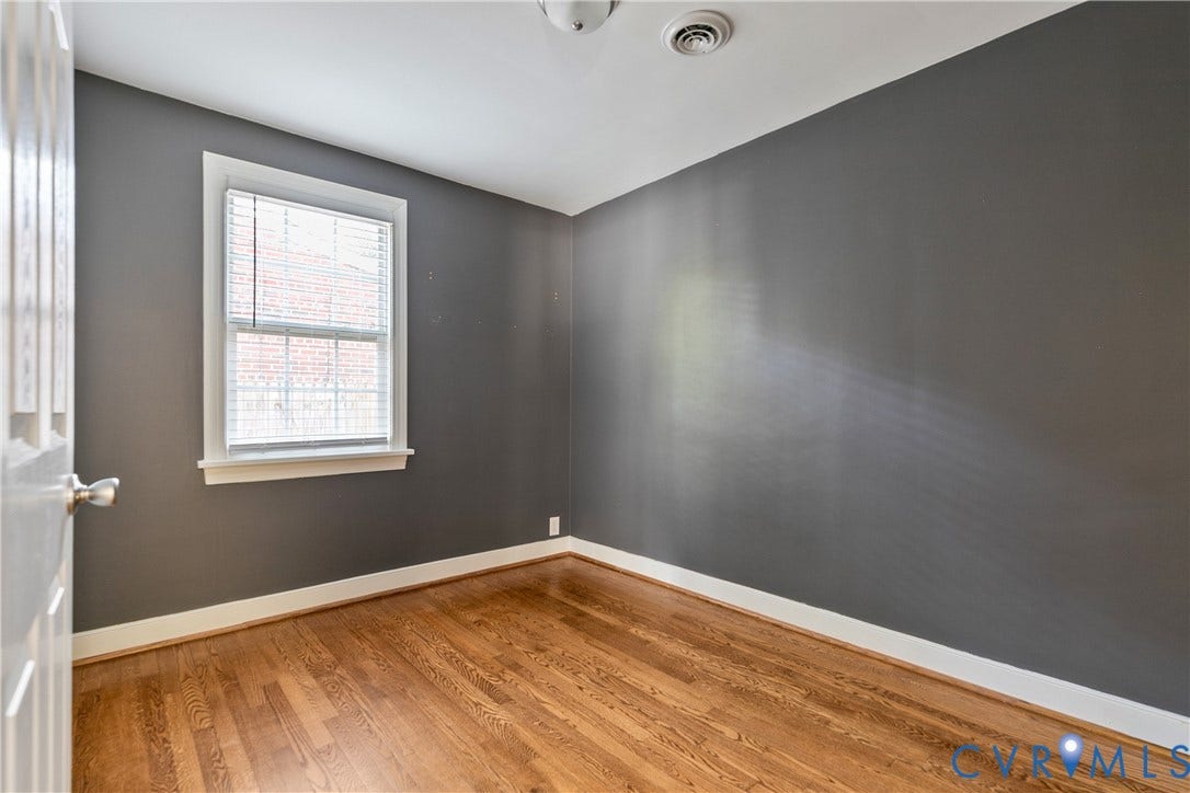 2108 Parkside Avenue, Henrico, VA 23228 Room featuring dark-toned walls, wood-finish flooring, and a single-hung window with white casing