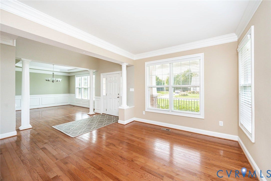 9118 Colonnade Circle, Ashland, VA 23005 Open interior featuring wood-finish flooring, crown molding, white classical-style support columns, and wainscoting