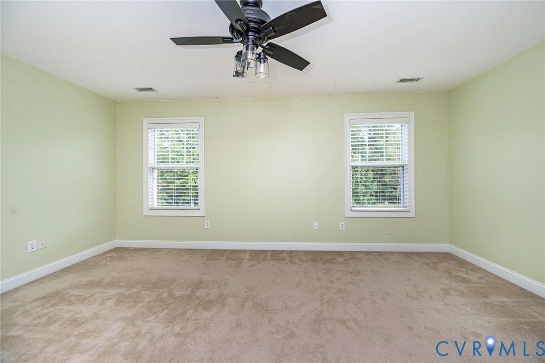 9118 Colonnade Circle, Ashland, VA 23005 Neutral-toned carpeted flooring, two double-hung windows with horizontal blinds, and a multi-blade ceiling fan with integrated lighting