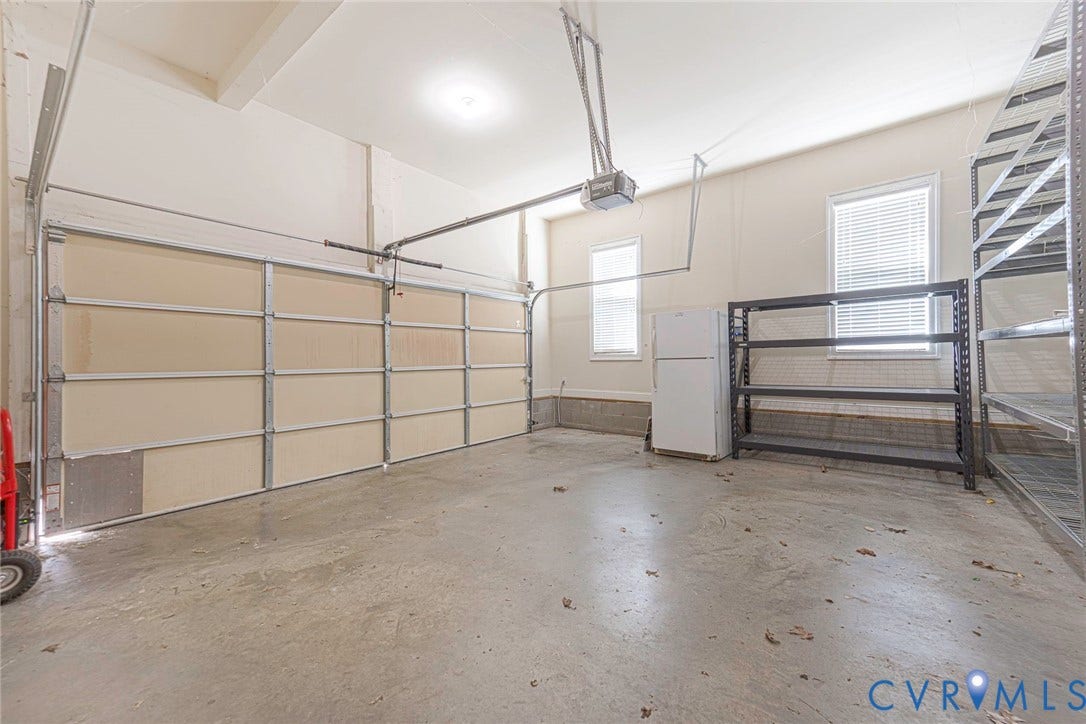9118 Colonnade Circle, Ashland, VA 23005 Multi-car garage featuring a concrete floor, high ceilings, automated door opener, and two windows providing natural light