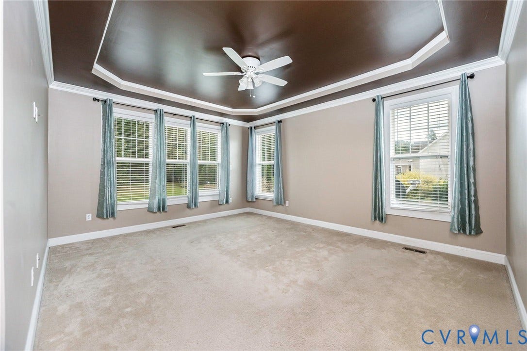 9118 Colonnade Circle, Ashland, VA 23005 Tray ceiling featuring a dark-toned inset, neutral wall color, wall-to-wall carpeting, multiple windows, and a central ceiling fan
