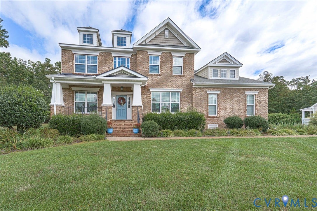 9118 Colonnade Circle, Ashland, VA 23005 Multi-story brick exterior featuring a covered front porch with white columns, dual dormer windows, multi-pane windows, and a shingle roof