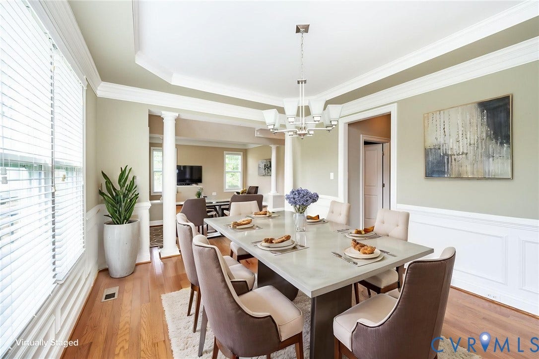 9118 Colonnade Circle, Ashland, VA 23005 Dining room featuring wood-finish flooring, white wainscoting, a tray ceiling, structural columns, and a multi-arm chandelier