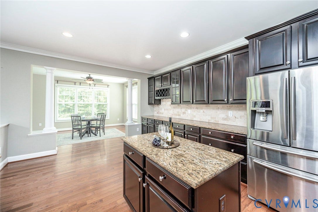 9118 Colonnade Circle, Ashland, VA 23005 Kitchen featuring dark cabinetry, stone countertops, a center island, stainless steel refrigerator, and recessed lighting