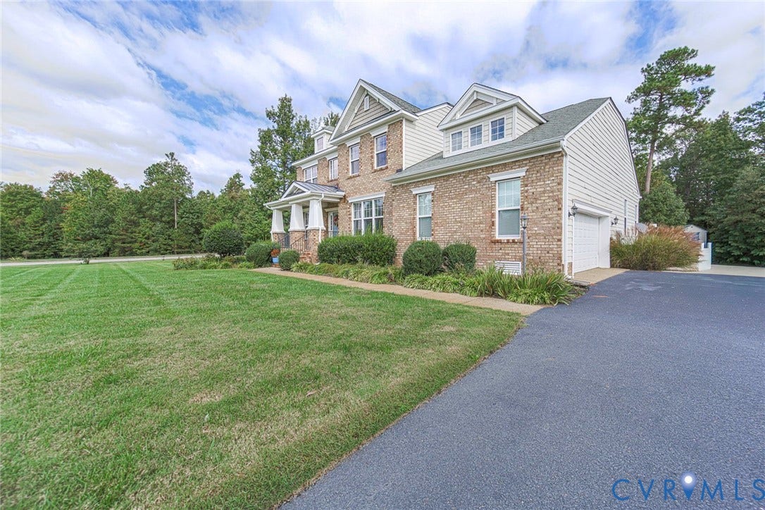 9118 Colonnade Circle, Ashland, VA 23005 Multi-story exterior featuring a brick and siding facade, a gabled roofline with dormers, a covered front entry with columns, and an attached side-load garage