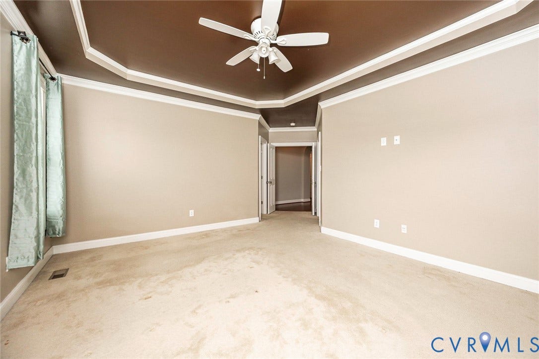 9118 Colonnade Circle, Ashland, VA 23005 Tray ceiling with recessed architectural detailing, neutral wall tones, and a ceiling-mounted fan with integrated lighting