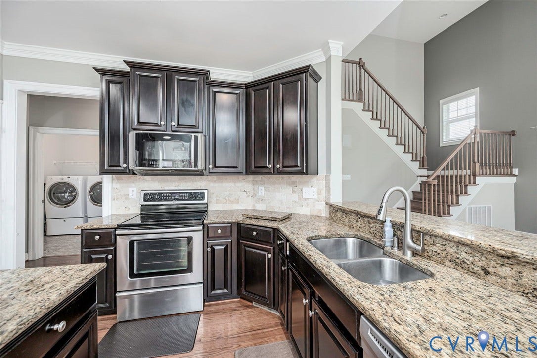 9118 Colonnade Circle, Ashland, VA 23005 Kitchen featuring dark-finish cabinetry, stone countertops, stainless steel appliances, a tile backsplash, and wood-finish flooring