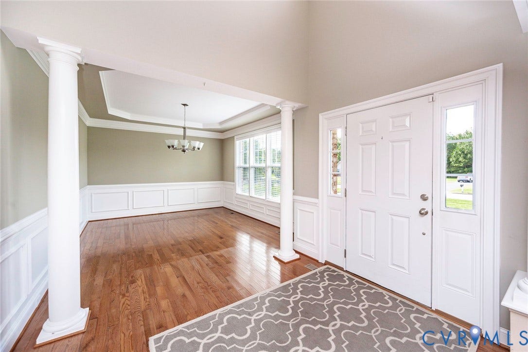 9118 Colonnade Circle, Ashland, VA 23005 Foyer featuring vaulted ceilings, wood-finish flooring, decorative columns, wainscoting, and a multi-light chandelier