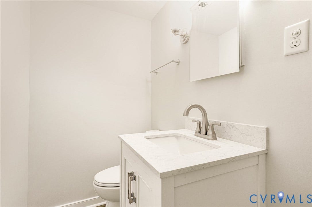 4 Millstone Road, The Hamlet, Henrico, VA 23228 White vanity cabinet with a stone-composite countertop, undermount sink, brushed-nickel faucet, and matching wall-mounted mirror