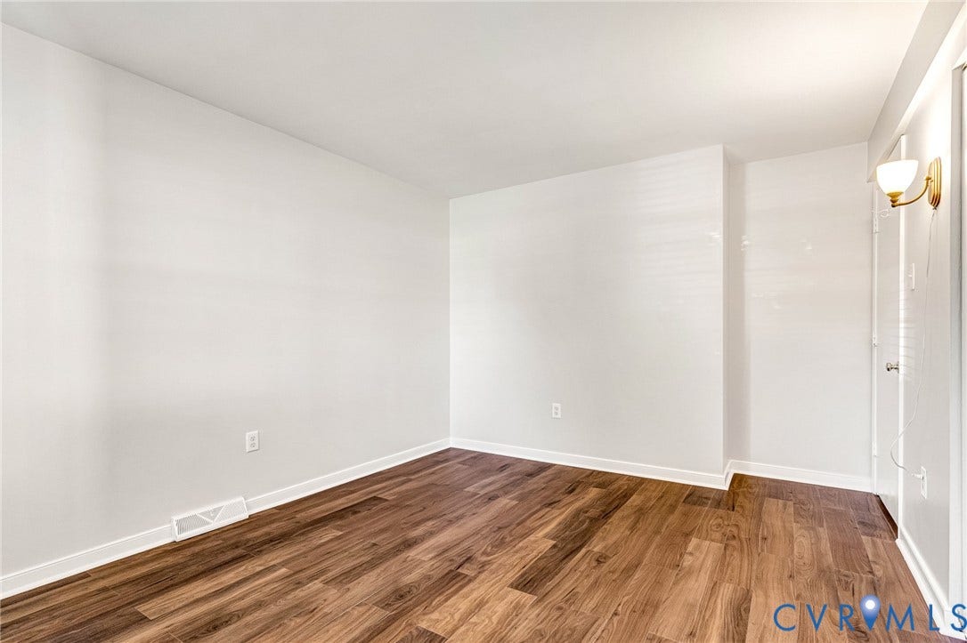 4 Millstone Road, The Hamlet, Henrico, VA 23228 Room featuring wood-finish flooring, white walls, and a wall-mounted brass and glass sconce