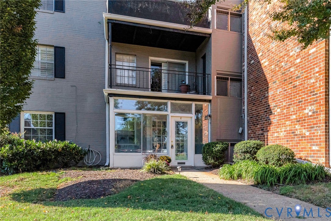 4 Millstone Road, The Hamlet, Henrico, VA 23228 Exterior featuring a brick and painted masonry facade, a private upper-level balcony with a black metal railing, and a ground-level sunroom with glass-paneled entry door