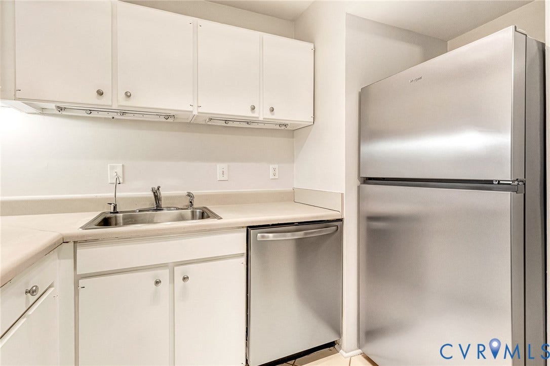 4 Millstone Road, The Hamlet, Henrico, VA 23228 Kitchen area featuring white cabinetry, neutral-toned solid surface countertops, a stainless steel dishwasher, and a top-mount stainless steel refrigerator