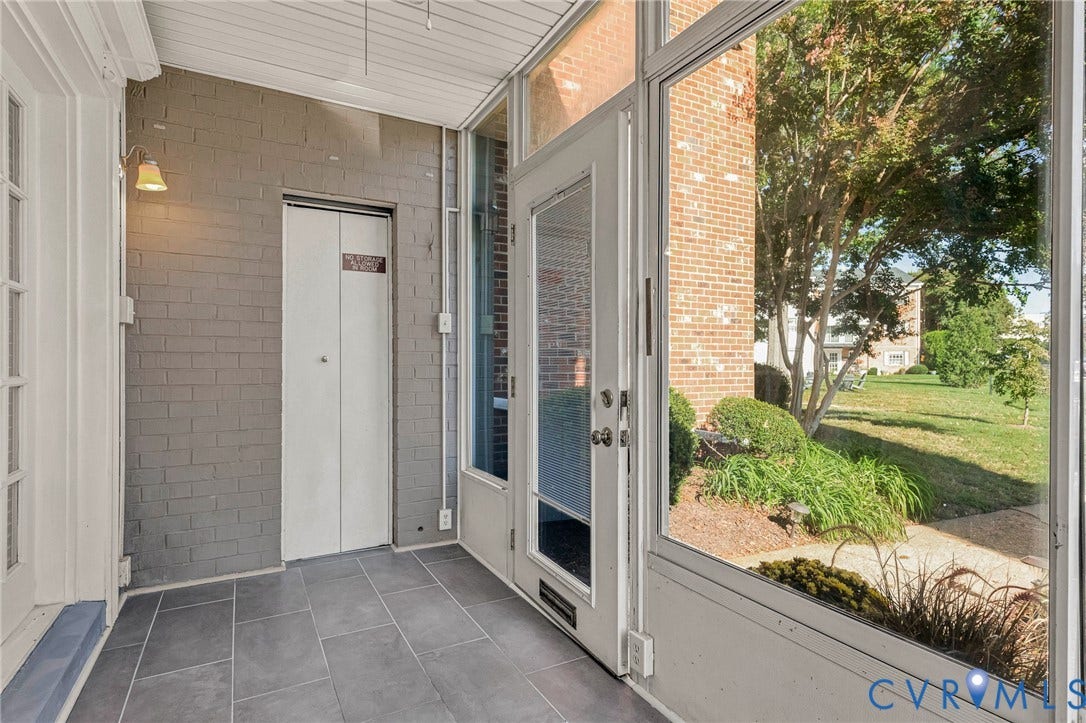 4 Millstone Road, The Hamlet, Henrico, VA 23228 Enclosed porch featuring large-format tile flooring, painted brick walls, a built-in storage closet, and floor-to-ceiling glass paneling