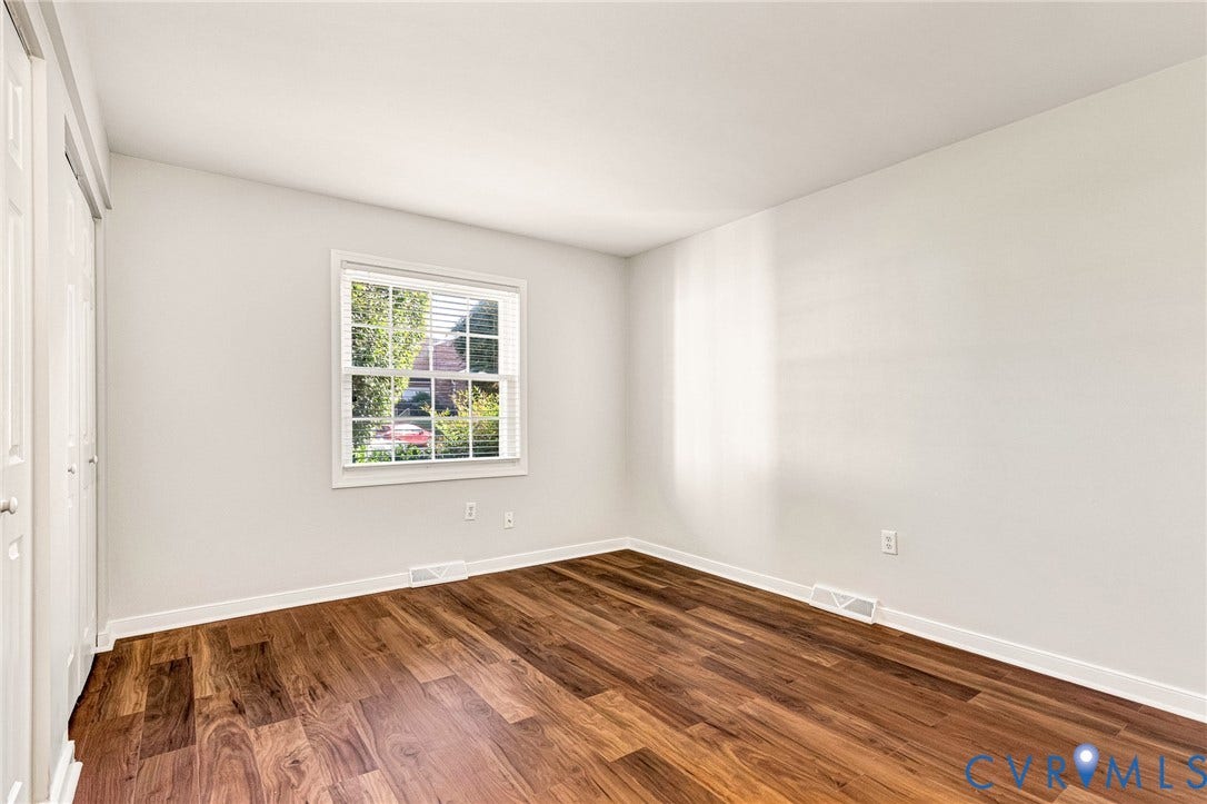 4 Millstone Road, The Hamlet, Henrico, VA 23228 Neutral wall-toned room featuring wood-finish flooring, a multi-pane window, and white dual-panel closet doors