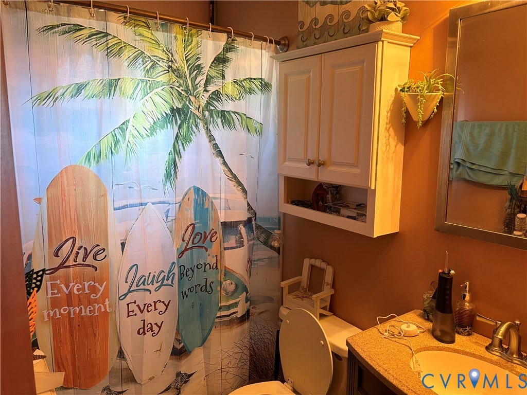 106 Verbov Avenue, Lundsford, Colonial Heights, VA 23834 Bathroom featuring a vanity with a composite countertop and integrated basin, a wall-mounted white cabinetry unit with two doors, and a rectangular wall-mounted mirror