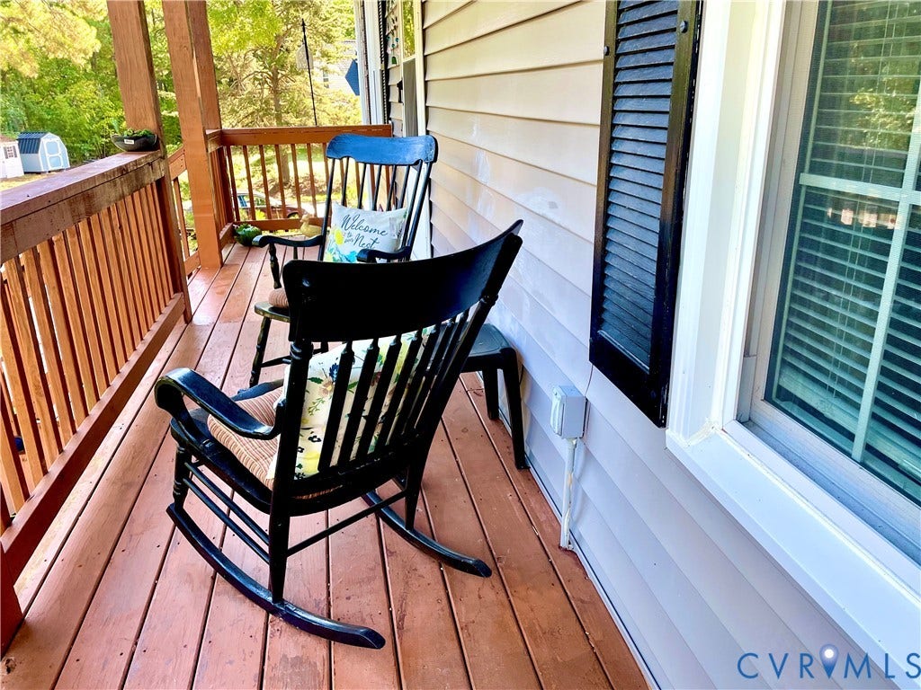 11801 New Forest Court, Chesterfield, VA 23112 Covered porch featuring wood-finish decking, natural wood railings, horizontal siding, and decorative window shutters