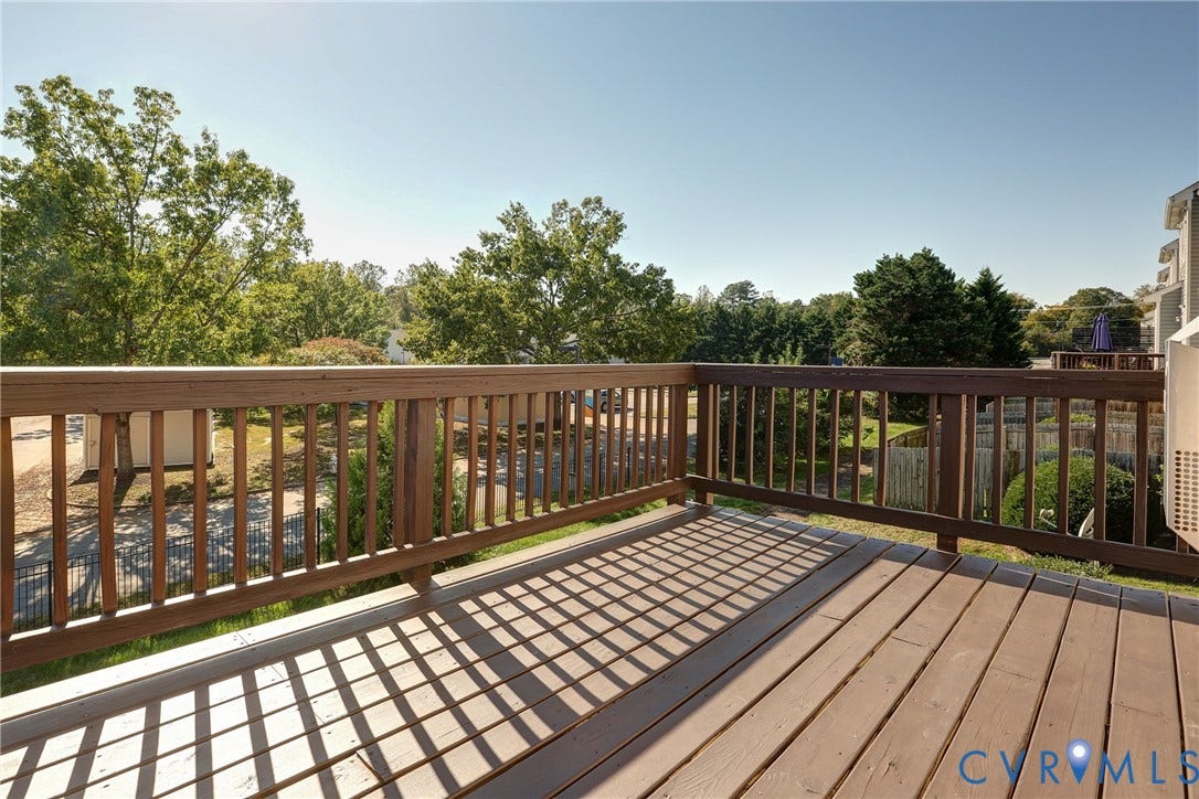 Elevated wooden deck featuring vertical baluster railings and plank flooring