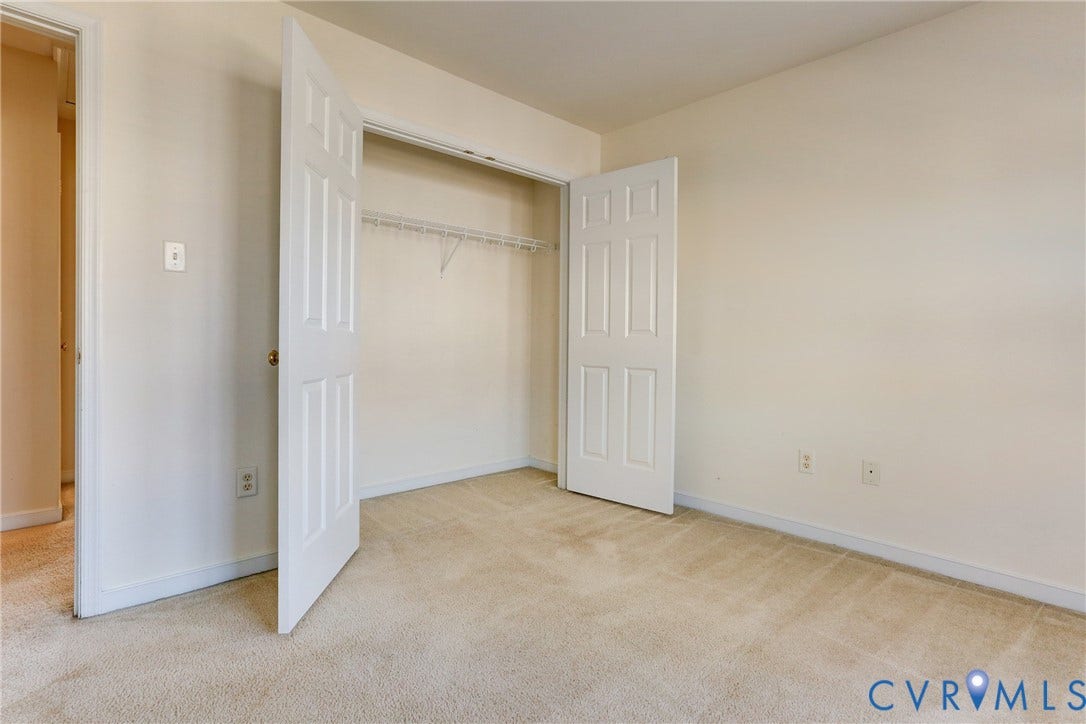 Neutral-toned interior featuring wall-to-wall carpeting and a reach-in closet with double doors