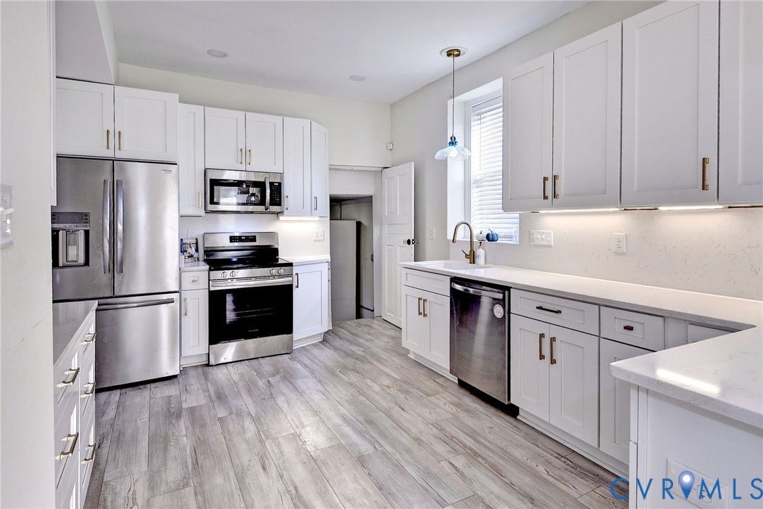 730 N 23RD Street, Union Hill, Richmond, VA 23223 Kitchen featuring white shaker-style cabinetry, stainless steel appliances, quartz countertops and under-cabinet lighting.