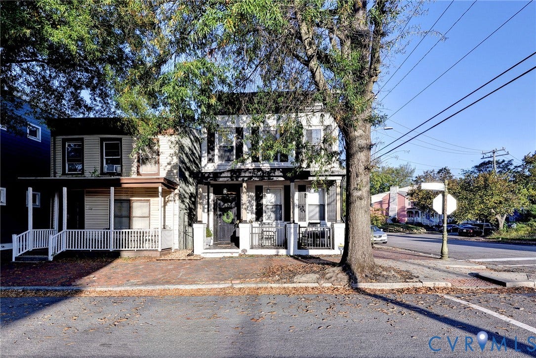 730 N 23RD Street, Union Hill, Richmond, VA 23223 Two-story exterior featuring a symmetrical facade with dark window shutters, a covered front porch with a built-in railing, and brick sidewalks.
