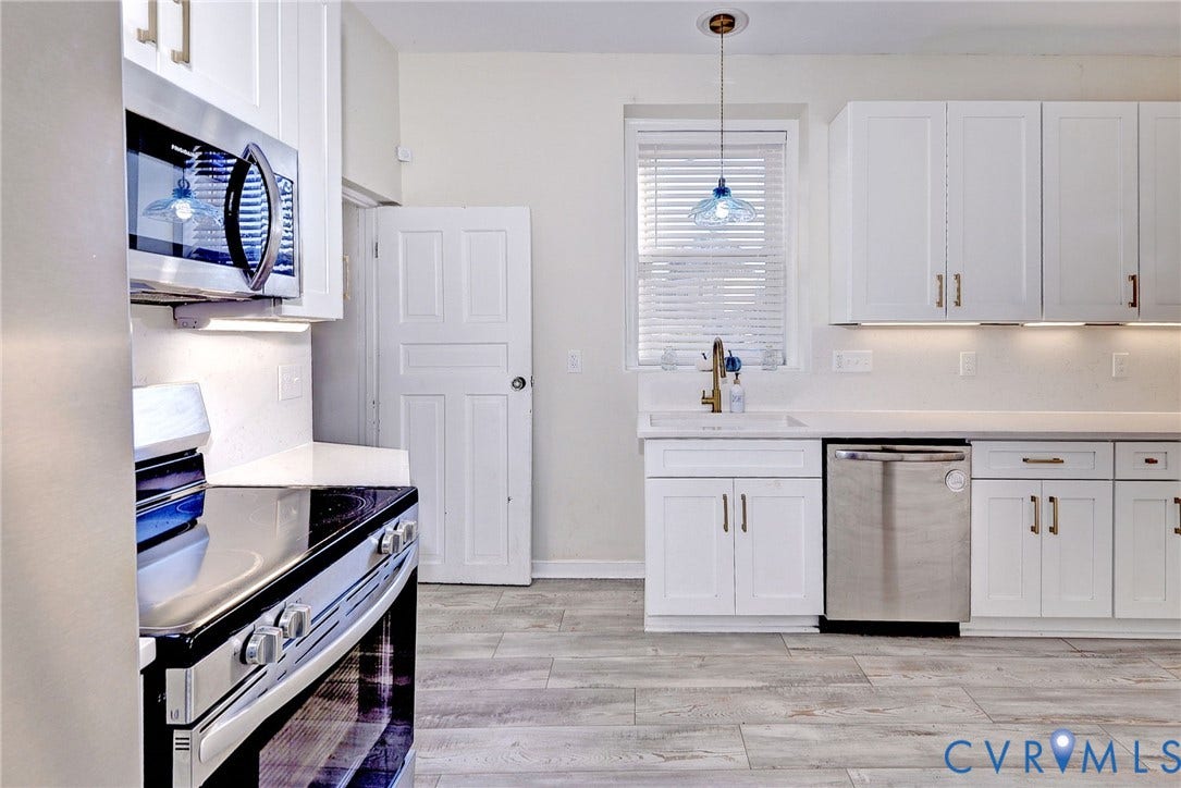 730 N 23RD Street, Union Hill, Richmond, VA 23223 Kitchen featuring white shaker-style cabinetry, solid-surface countertops, stainless steel appliances and a brass-accents.