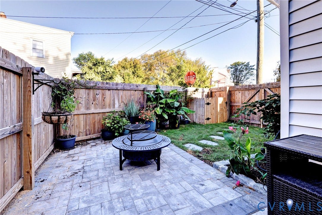 730 N 23RD Street, Union Hill, Richmond, VA 23223 Private backyard featuring a paver stone patio, wood privacy fencing, a manicured lawn, stone pathway, and perimeter landscaping