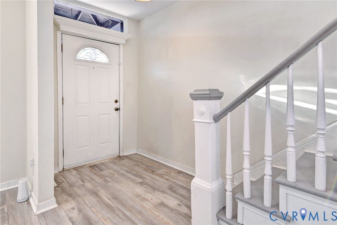 730 N 23RD Street, Union Hill, Richmond, VA 23223 Entryway featuring a historic transom window and a staircase with a painted wood banister and decorative newel post.