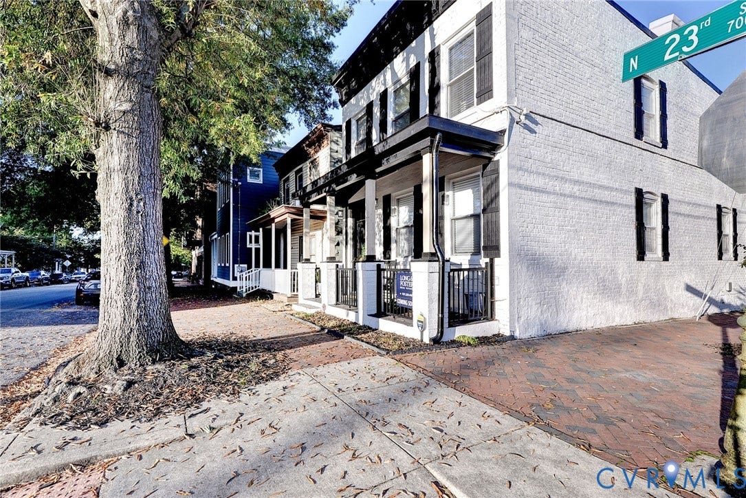 730 N 23RD Street, Union Hill, Richmond, VA 23223 White painted brick exterior featuring black shutters, a covered front porch, and classic brick pavers.