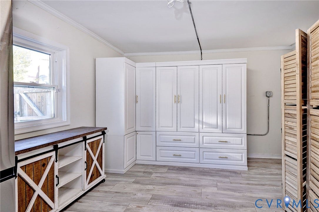 730 N 23RD Street, Union Hill, Richmond, VA 23223 Built-in white cabinetry with drawers, wood-finish flooring, and a sliding barn-door style storage console